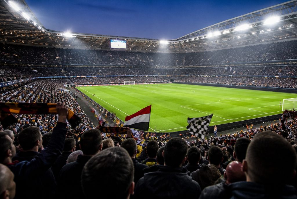 Fullsatt fotbollsarena i kvällsljus